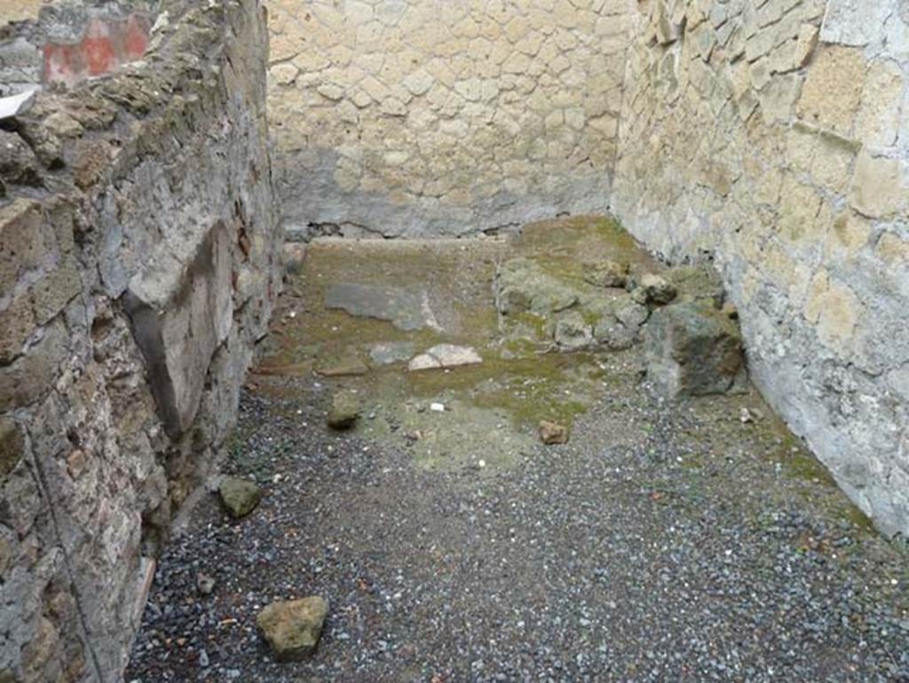 IV.8, Herculaneum, September 2015.
Room 2, kitchen and latrine, looking north into second area, on north side of entrance doorway.
This was a type of vestibule leading to the kitchen and latrine, with the hearth in a corner and the latrine under the stairs. Large tiles form the floor.